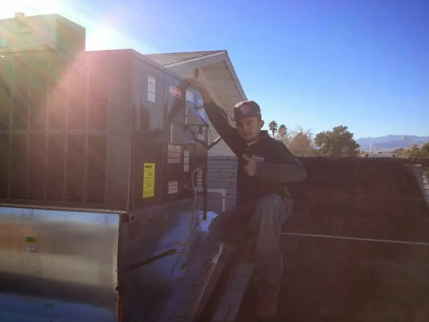 HVAC technician performing Heat Pump Repair on a rooftop unit in Ewing
